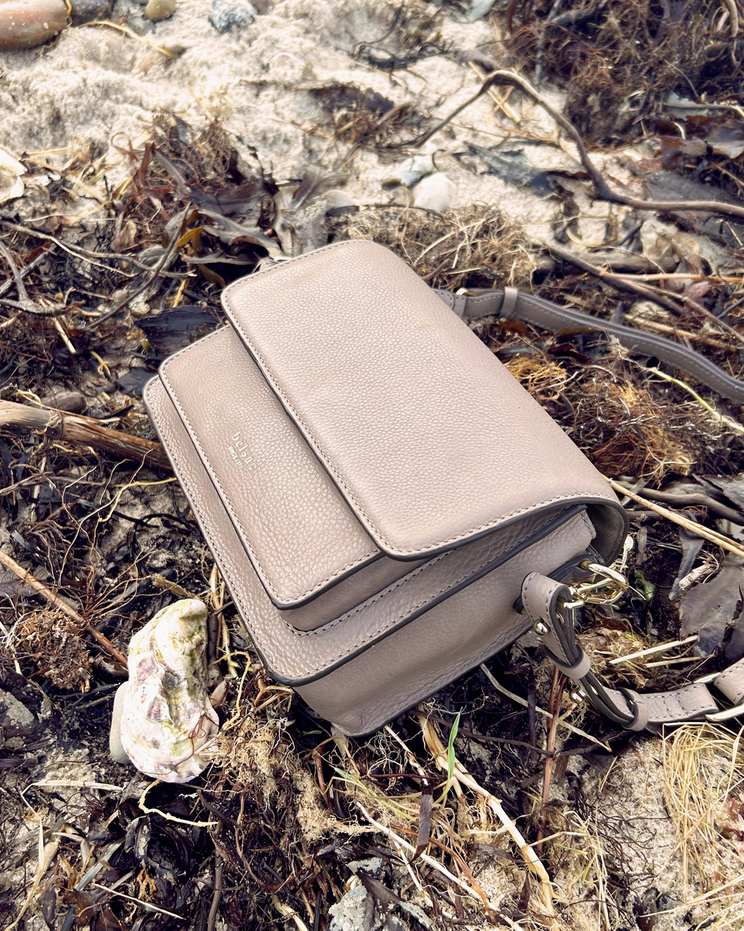 Olga Taupe Crossbody taske i laeder 26402 5 paa en strand Belsac Creative