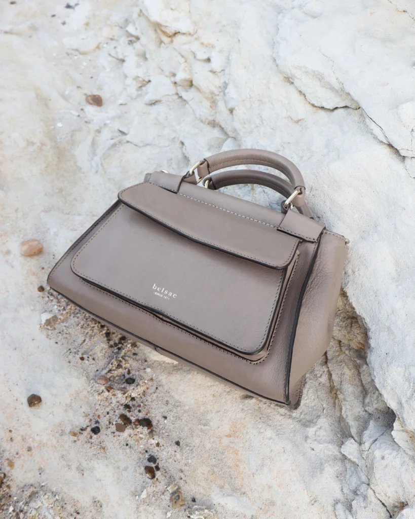 Rachel taupe Crossbody taske i laeder 26501 5 liggende paa hvide sten Belsac Creative
