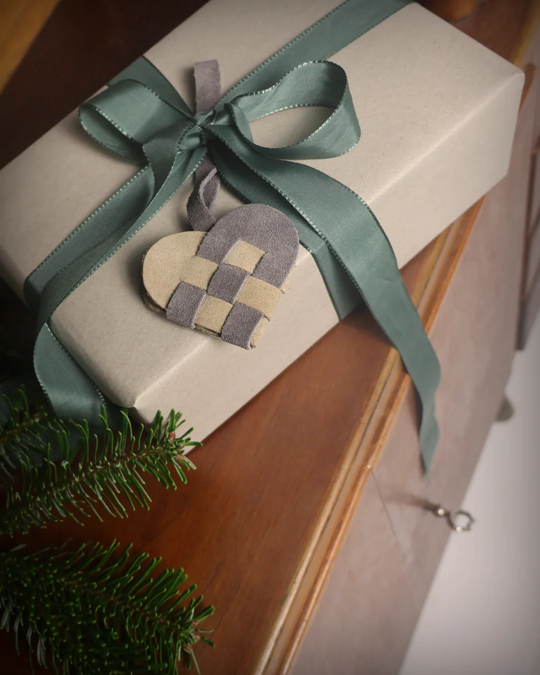 Flettede julehjerte i ruskind, grå. På pakke